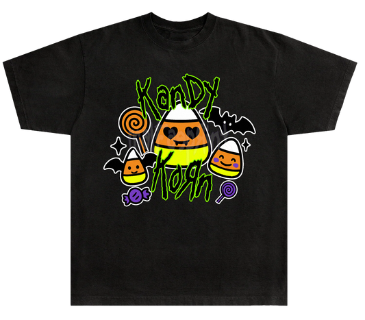 A black t-shirt with a Halloween-themed graphic design featuring a candy corn surrounded by various Halloween-themed elements such as bats, a bat-shaped lollipop, and a bat-shaped candy cane.