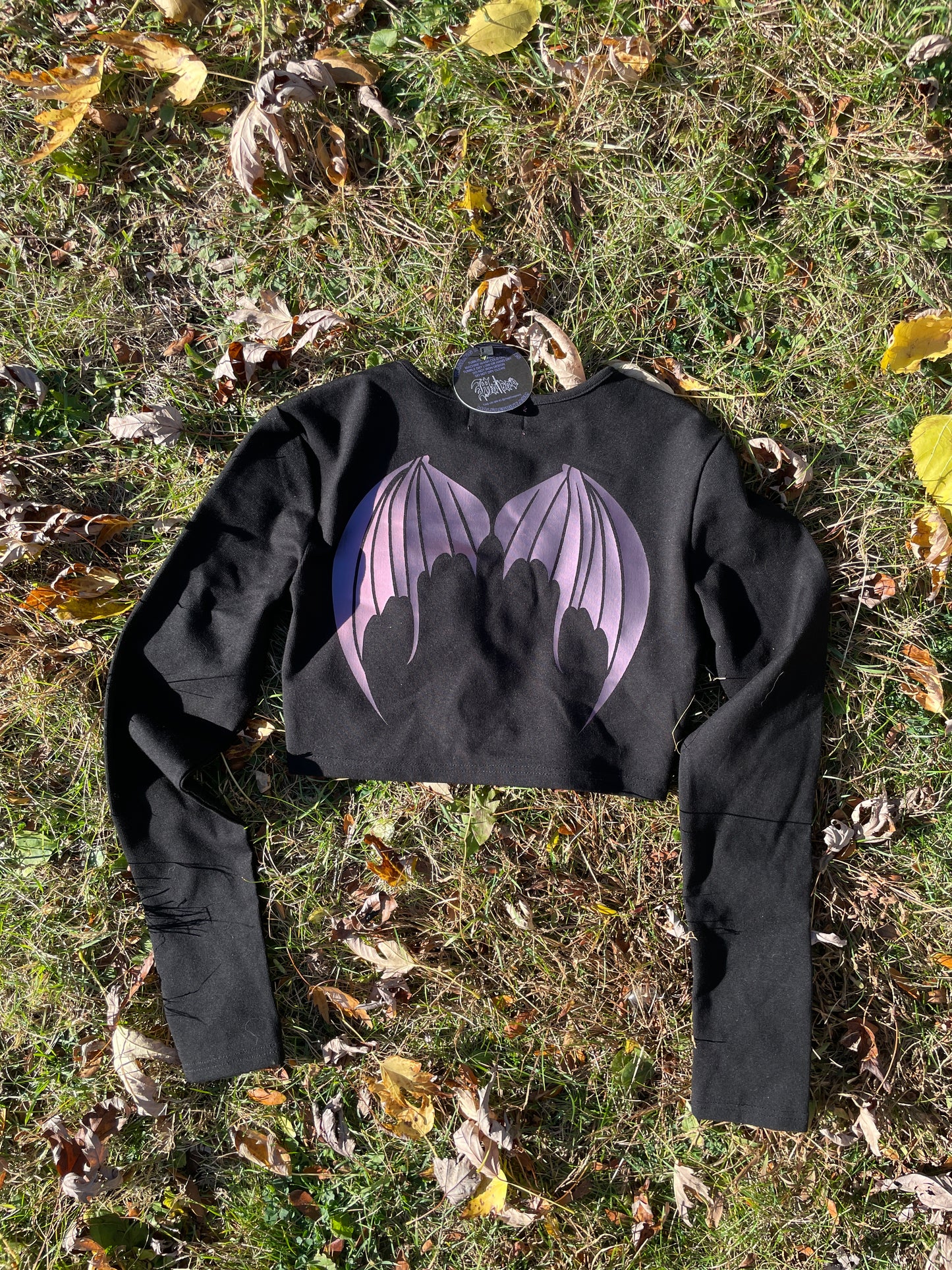 a black shirt laying on top of a grass covered field