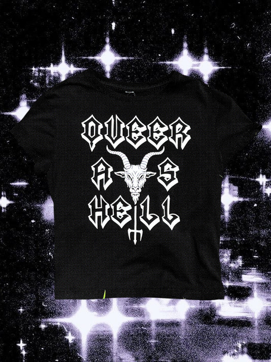 Black baby tee with white gothic-style lettering that says “QUEER AS HELL.” The graphic features a goat head centered between the words and a trident.” The shirt is laid flat on a black-and-white cosmic starry background.