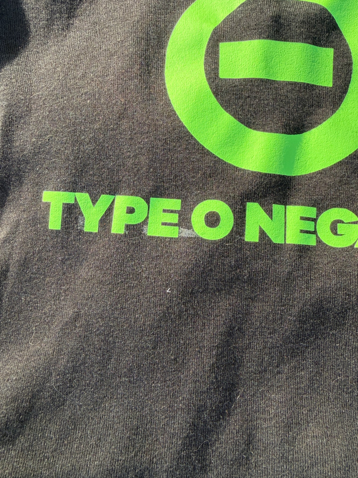 a close-up view of a dark-colored fabric with a large green logo and text printed on it.