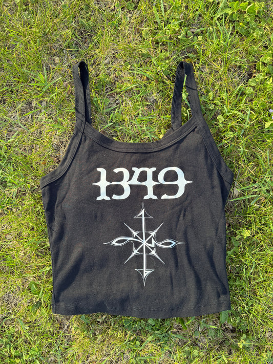 A black tank top with white text and a graphic design is lying on the grass.