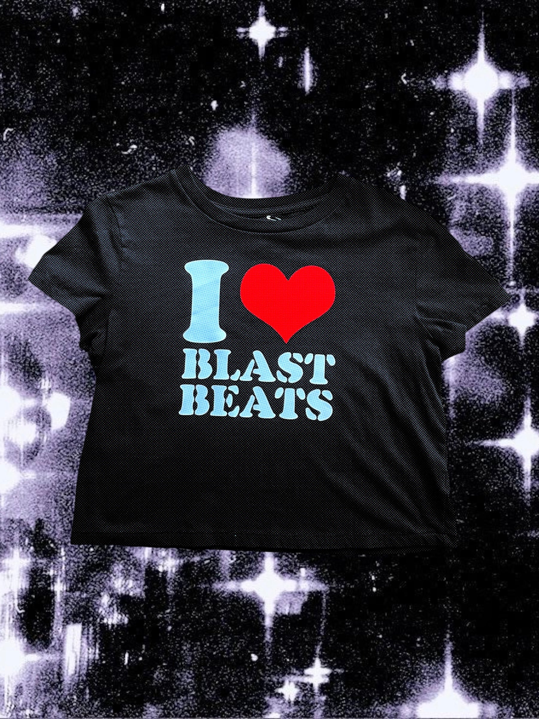 Black cropped t-shirt with a retro-style print that says “I ❤️ BLAST BEATS” in white text and a large red heart. The shirt is laid flat over a sparkly black-and-white cosmic background.
