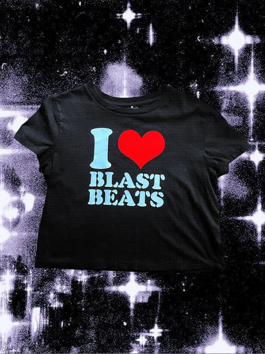 Black cropped t-shirt with a retro-style print that says “I ❤️ BLAST BEATS” in white text and a large red heart. The shirt is laid flat over a sparkly black-and-white cosmic background.