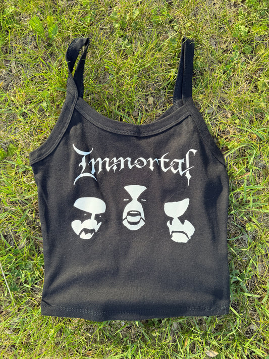 A black crop top with white text printed on it, lying on the grass.