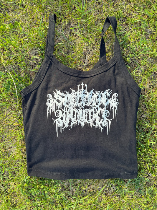 A black crop top with white text printed on it, lying on a grassy surface.