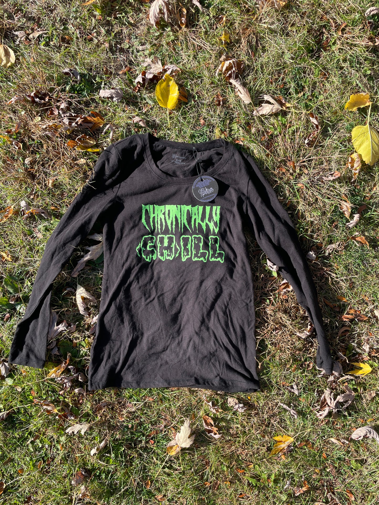 a black shirt laying on top of a grass covered field